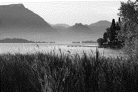 Dithered photograph of a lake below hills