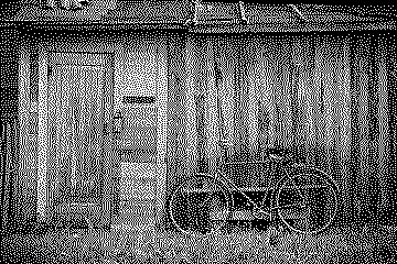 Dithered photograph of a weathered wooden workshop with a bicycle